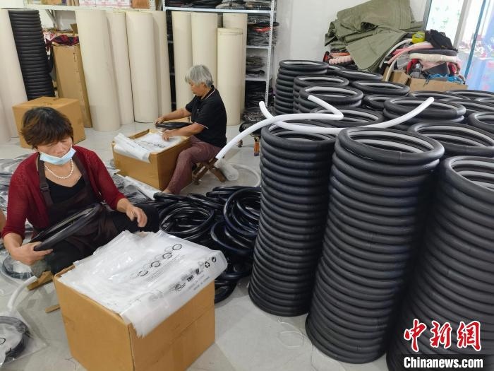 圖為村民在汽車飾品企業(yè)生產(chǎn)車間中工作?！巫雍?攝