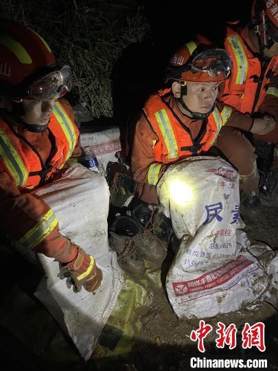 短暫修整期間，消防員脫掉鞋襪，用編織袋套住腿腳保暖。　閆旭輝 攝