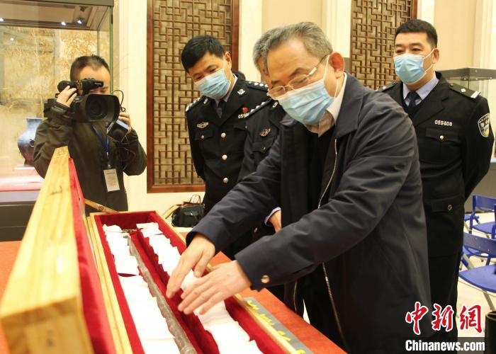 山東博物館館長(zhǎng)鄭同修介紹涉案文物龍首錯(cuò)銀木柲銅杖。　趙曉 攝