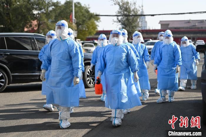 圖為醫(yī)務(wù)人員在封閉小區(qū)做防控工作?！⑽娜A 攝