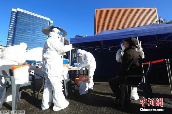 資料圖：韓國(guó)首爾，醫(yī)務(wù)人員對(duì)市民進(jìn)行新冠病毒檢測(cè)。