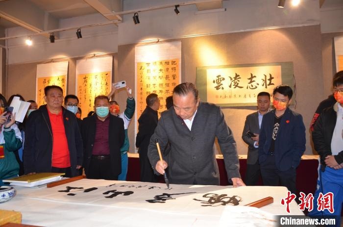 圖為“鐵軍老戰(zhàn)士”、著名書法家、解放軍報(bào)原副總編輯連俊義少將現(xiàn)場揮毫?！☆佇玛?攝 攝