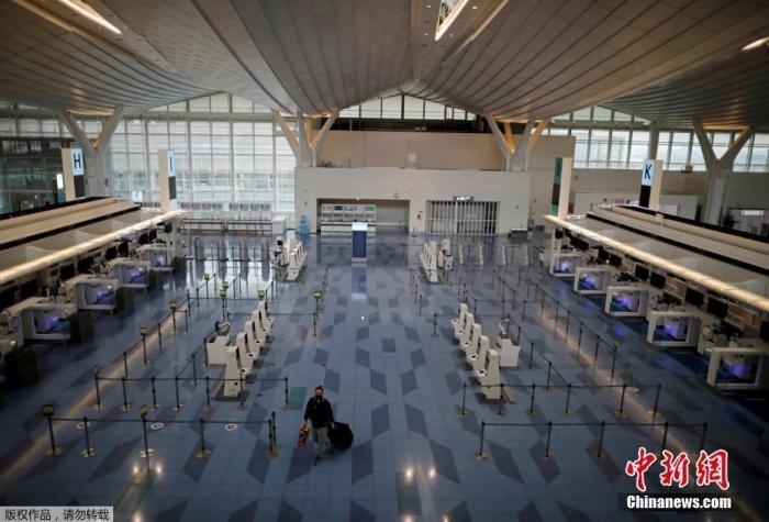 資料圖：日本東京，東京國際機(jī)場，一名乘客在國際航班航站樓的登機(jī)區(qū)。