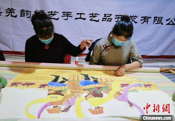 圖為皮繡藝人在市集上“秀”指尖技藝。　馬銘言 攝