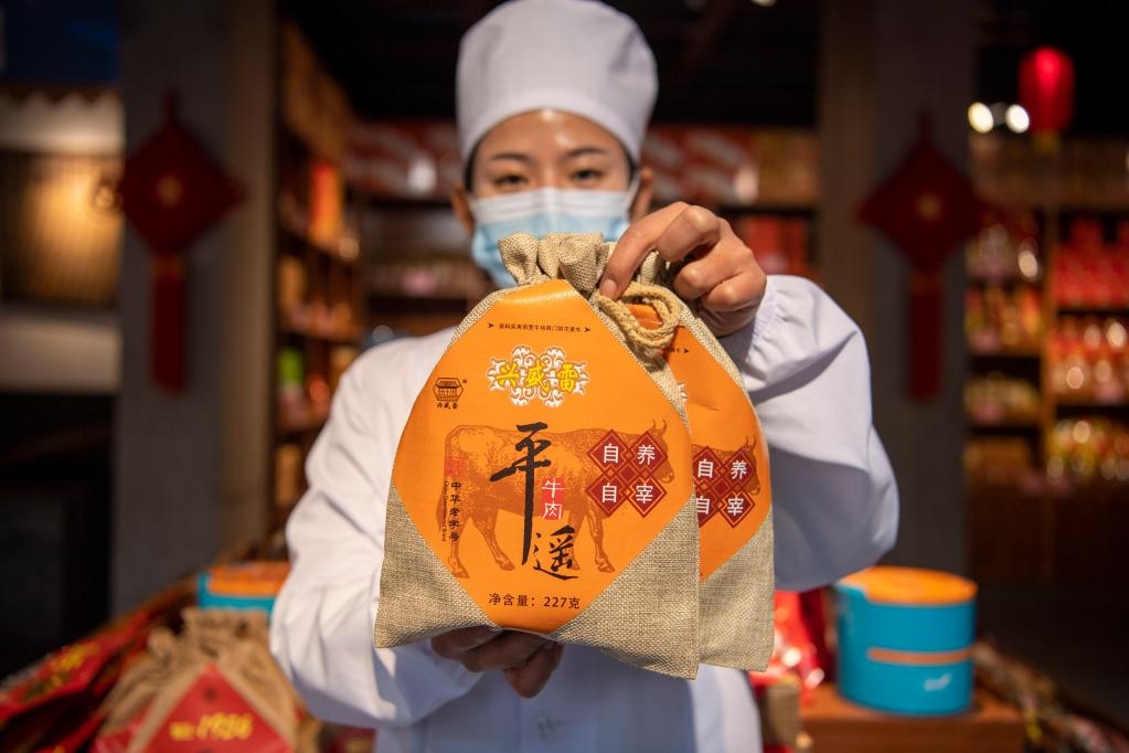 1月27日，在平遙古城南大街的一家平遙牛肉店內(nèi)，工作人員展示一款牛肉產(chǎn)品。新華社記者 楊晨光 攝