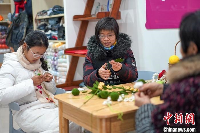 文創(chuàng)工作室的姐妹們正在鉤織月桂葉片。　古良駒 攝