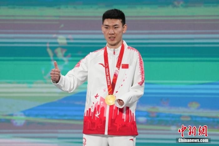 3月6日，梁景怡在延慶頒獎(jiǎng)廣場(chǎng)領(lǐng)獎(jiǎng)臺(tái)上豎起大拇指。當(dāng)日，在國(guó)家高山滑雪中心舉行的北京2022年冬殘奧會(huì)殘奧高山滑雪男子超級(jí)大回轉(zhuǎn)—站姿決賽中，中國(guó)選手梁景怡奪得冠軍。 <a target='_blank' href='/'>中新社</a>記者 楊華峰 攝