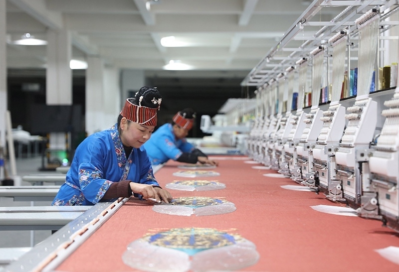 2023年2月13日，貴州省黔東南苗族侗族自治州施秉縣工業(yè)園區(qū)，工人在機(jī)繡車間作業(yè)。