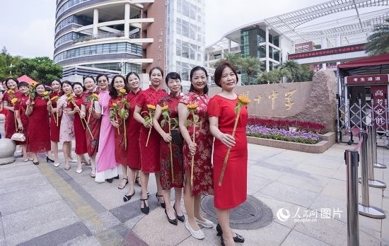 6月7日一早，廈門雙十中學(xué)考生家長們身穿旗袍，手拿向日葵在考場外為孩子加油打氣，寓意“旗開得勝，一舉奪魁”。人民網(wǎng)記者 陳博攝