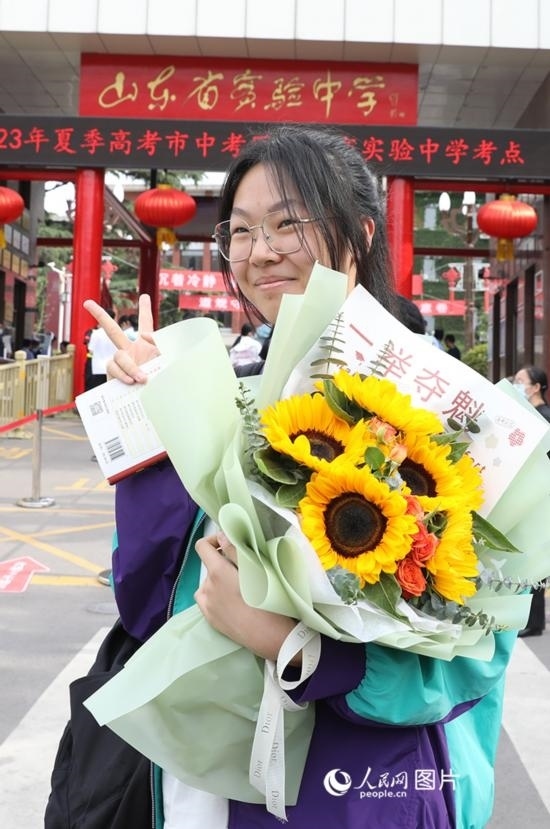 6月7日高考首日，山東67萬考生走進(jìn)考場，拼搏逐夢。在山東省實驗中學(xué)考點，考生進(jìn)考場前手捧向日葵花拍照留念，寓意“一舉奪魁”。人民網(wǎng)記者 劉祺攝