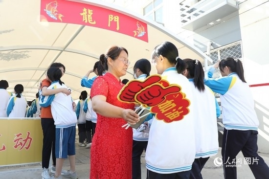 6月7日一早，雄安新區(qū)安新中學(xué)老師在給同學(xué)們加油鼓勁兒。人民網(wǎng) 李兆民攝