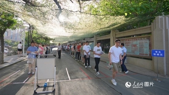 6月7日，烏魯木齊市第七十中學(xué)門口，考生們有序進(jìn)入考場。人民網(wǎng) 李欣洋攝