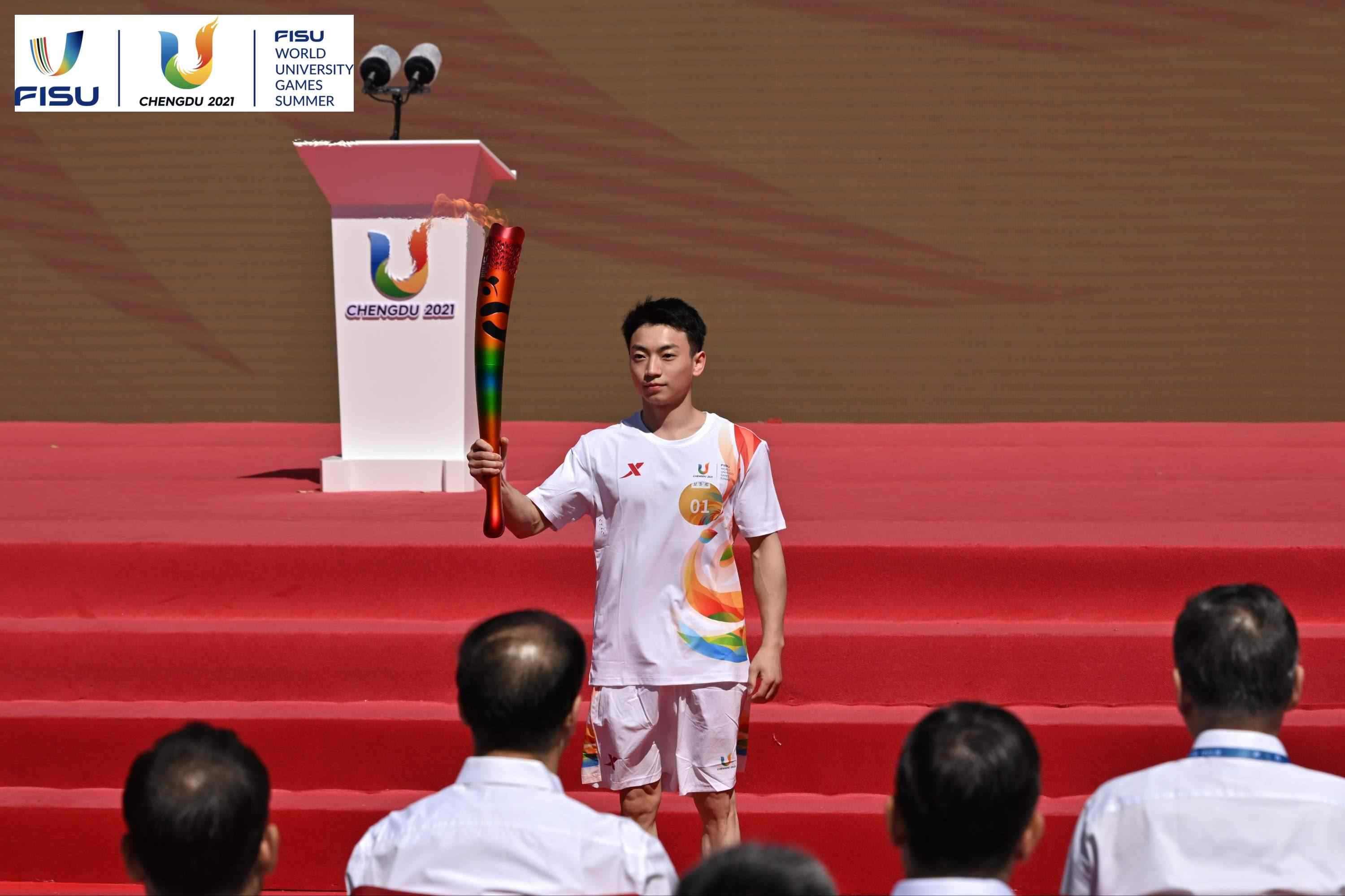 成都大運會火炬手、奧運冠軍鄒敬園高舉火炬。 圖片來源：成都大運會執(zhí)委會供圖