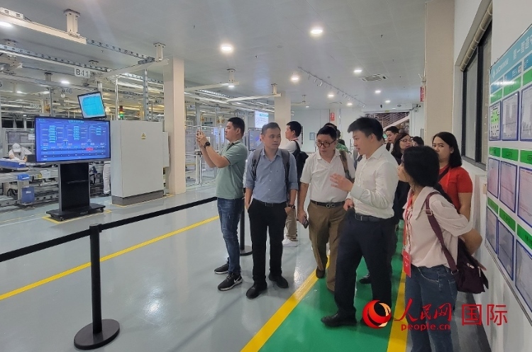 廣汽埃安工作人員向外媒記者進行介紹。人民網(wǎng) 寧玉瑛攝