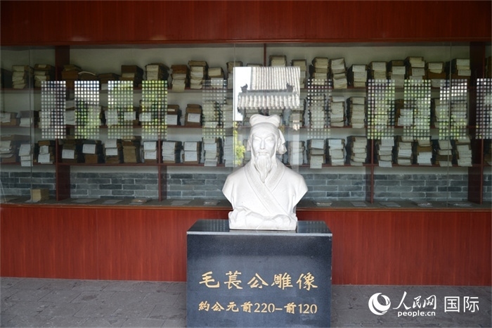 河間詩經(jīng)齋毛萇雕像。雕像后書櫥中陳列的是歷代各版本《詩經(jīng)》及譯本。 人民網(wǎng) 趙昭攝