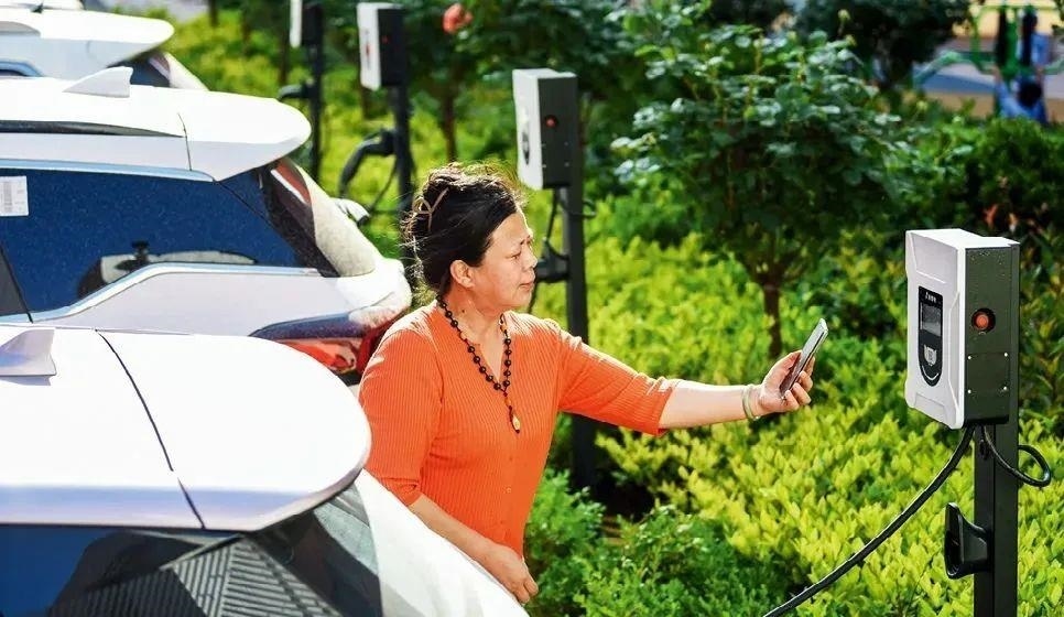 2023年5月24日，山東省膠州市新立街小區(qū)內(nèi)一位居民使用電動(dòng)汽車充電樁掃碼充電。該小區(qū)加裝各類智慧設(shè)備，打造“智慧社區(qū)”，為居民生活帶來(lái)便利。