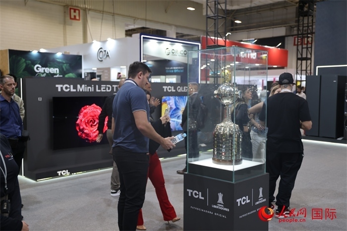 參觀者在TCL展臺前觀看南美解放者杯獎杯，據(jù)介紹，TCL是南美解放者杯（2023—2026賽季）全球官方合作伙伴。（人民網(wǎng)記者 時元皓攝）