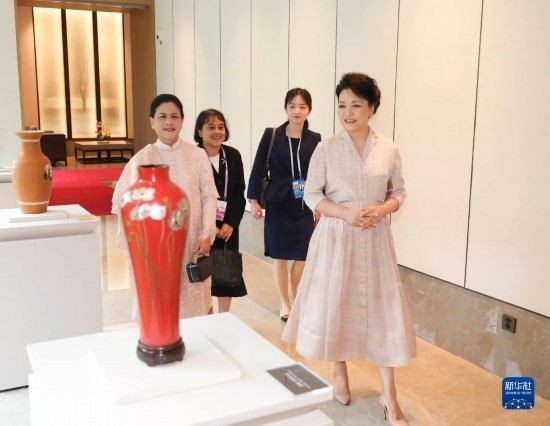 7月27日下午，國家主席習(xí)近平夫人彭麗媛在四川成都會(huì)見陪同印度尼西亞總統(tǒng)佐科來華出席第31屆世界大學(xué)生夏季運(yùn)動(dòng)會(huì)開幕式并訪華的總統(tǒng)夫人伊莉亞娜。這是彭麗媛和伊莉亞娜欣賞成都特色非遺工藝品。新華社記者 丁林 攝