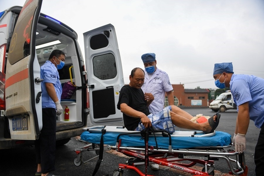 8月1日，在北京市門頭溝區(qū)妙峰山鎮(zhèn)妙峰山民族學(xué)校臨時(shí)安置點(diǎn)，北京急救中心工作人員在轉(zhuǎn)運(yùn)一名受傷村民。新華社記者 鞠煥宗 攝