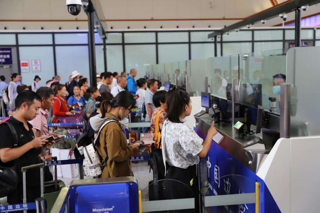 出境旅客在辦理通關(guān)手續(xù)。人民網(wǎng)記者 李發(fā)興攝