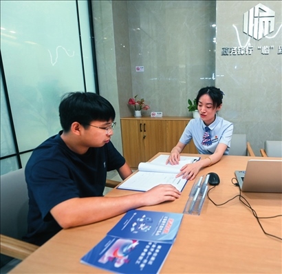 在杭州市臨安區(qū)政務服務中心的“為企服務中心”，黨員志愿者（右）解答企業(yè)主的疑問（2023年7月7日攝）。徐昱攝/本刊