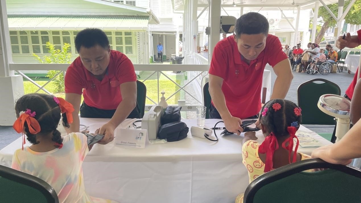 醫(yī)療隊(duì)員為福利院兒童進(jìn)行檢查。第18期援圭亞那醫(yī)療隊(duì)供圖