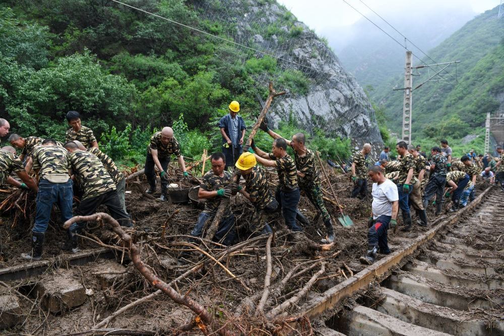 8月1日，在北京市門頭溝區(qū)水峪嘴村附近一段被阻斷的鐵路線上，中鐵六局工作人員在清理軌道上的雜物，全力恢復(fù)交通。新華社記者 鞠煥宗 攝