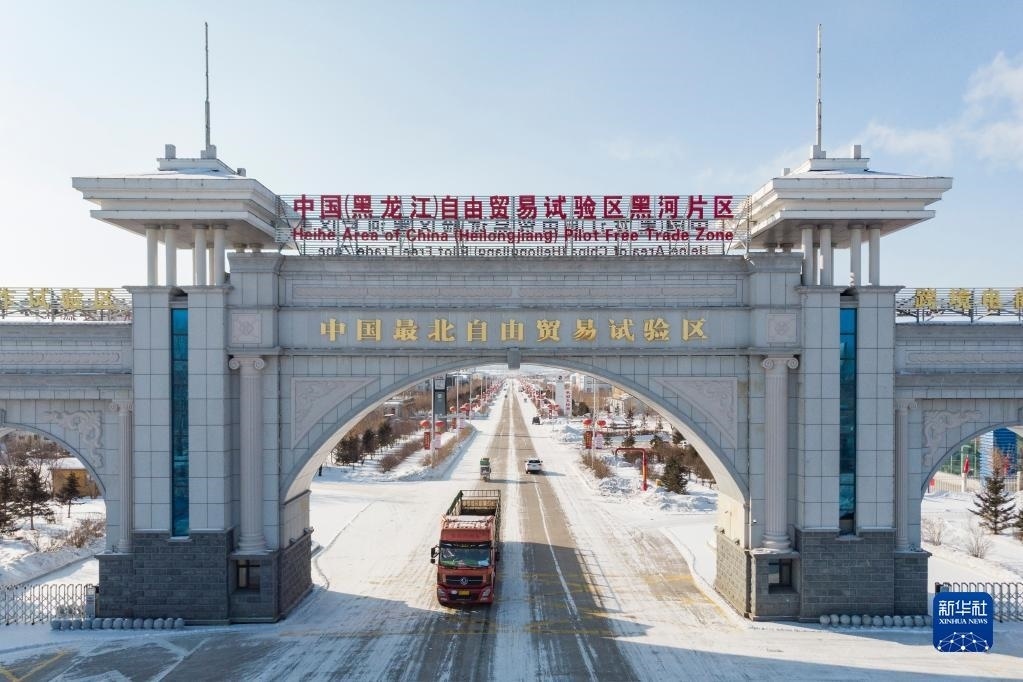 2月11日，車輛駛出中國(guó)（黑龍江）自由貿(mào)易試驗(yàn)區(qū)黑河片區(qū)大門（無(wú)人機(jī)照片）。新華社記者 謝劍飛 攝