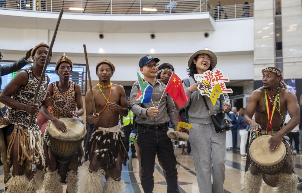 在南非約翰內(nèi)斯堡坦博國際機(jī)場，南非舞蹈演員歡迎中國試點(diǎn)恢復(fù)出境團(tuán)隊(duì)旅游后首批抵達(dá)南非的中國游客（2023年3月29日攝）。