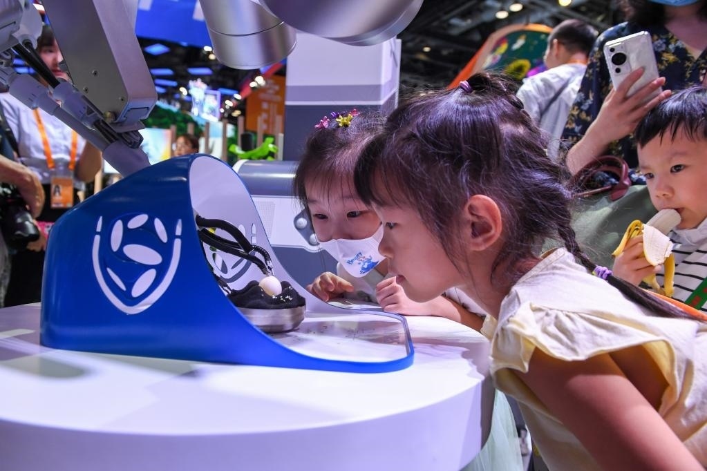 9月3日，幾名小朋友在國家會議中心觀看單孔腔鏡手術(shù)機器人展示。新華社記者 鞠煥宗 攝