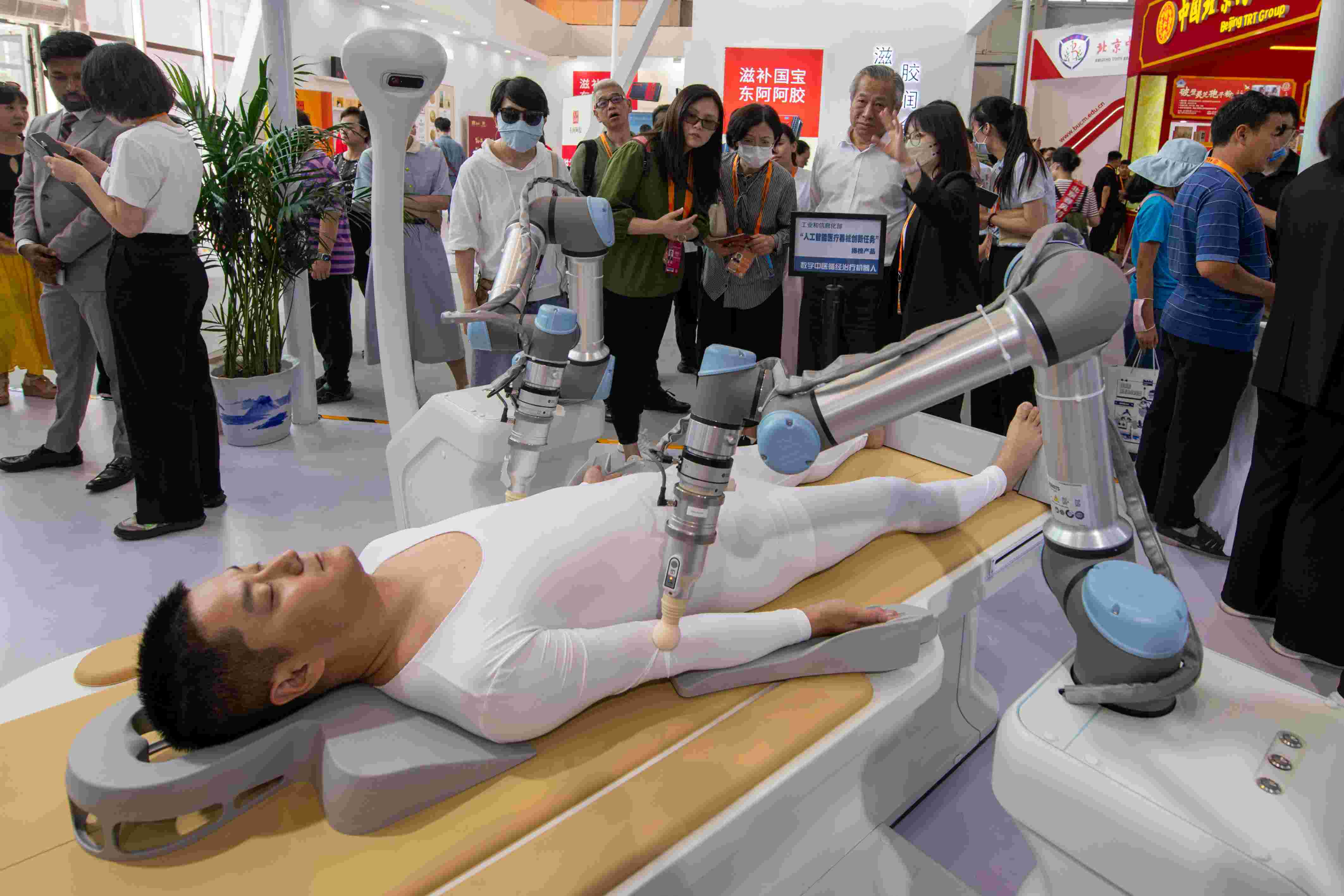 在位于首鋼園的健康衛(wèi)生服務(wù)展區(qū)，觀眾正在參觀數(shù)字中醫(yī)循經(jīng)治療機(jī)器人。人民網(wǎng)記者 翁奇羽攝