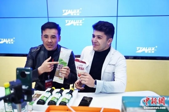 2023年3月，甘肅省慶陽市環(huán)縣電商創(chuàng)業(yè)孵化基地內(nèi)，來自蘭州文理學院的塔吉克斯坦留學生正在協(xié)助主播直播帶貨當?shù)剞r(nóng)特產(chǎn)品。李亞龍 攝