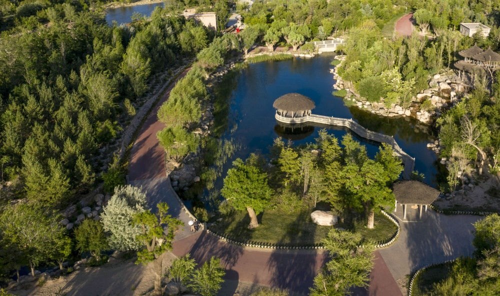 坐落在寧夏銀川市賀蘭山腳下的賀蘭山運動休閑公園（2021年5月27日攝，無人機照片）。這里曾是一片砂石采礦塌陷區(qū)，當(dāng)?shù)赝ㄟ^植被景觀再造、水系建設(shè)、現(xiàn)代管網(wǎng)鋪建等手段，重新利用廢石、廢坑及各類廢棄建筑材料，把這里變成一座免費開放的主題公園。新華社記者 馮開華 攝