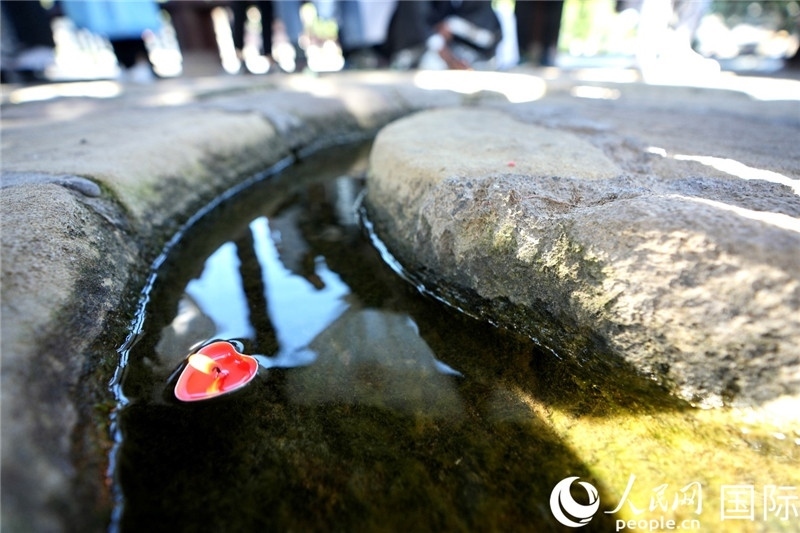 圖為水渠里流過的“桃心”蠟燭。人民網(wǎng) 盧鵬宇攝
