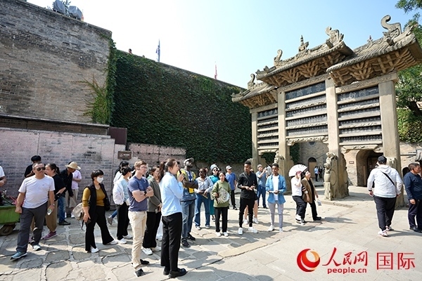 選手們認真聆聽導游講解。人民網(wǎng) 盧鵬宇攝