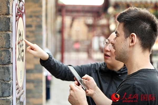 選手安德烈（俄羅斯）在老師指導下學習墻壁上張貼的生僻字。人民網(wǎng) 盧鵬宇攝