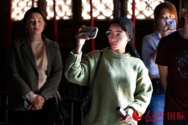 選手顏青（蘇丹）用手機記錄所見所感。人民網(wǎng) 盧鵬宇攝