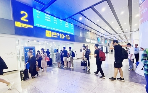 在快速進(jìn)站廳前排隊等待檢票的旅客。人民網(wǎng)記者 喬雪峰攝