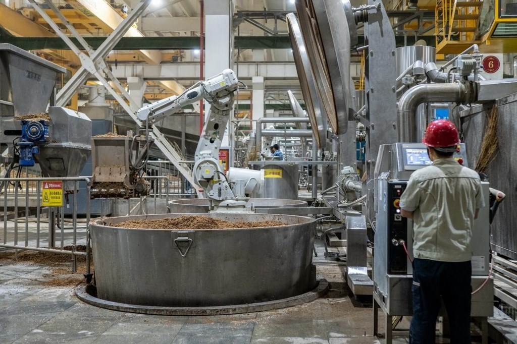 907車間里，機(jī)械臂正在撒料裝甑。嚴(yán)磊攝