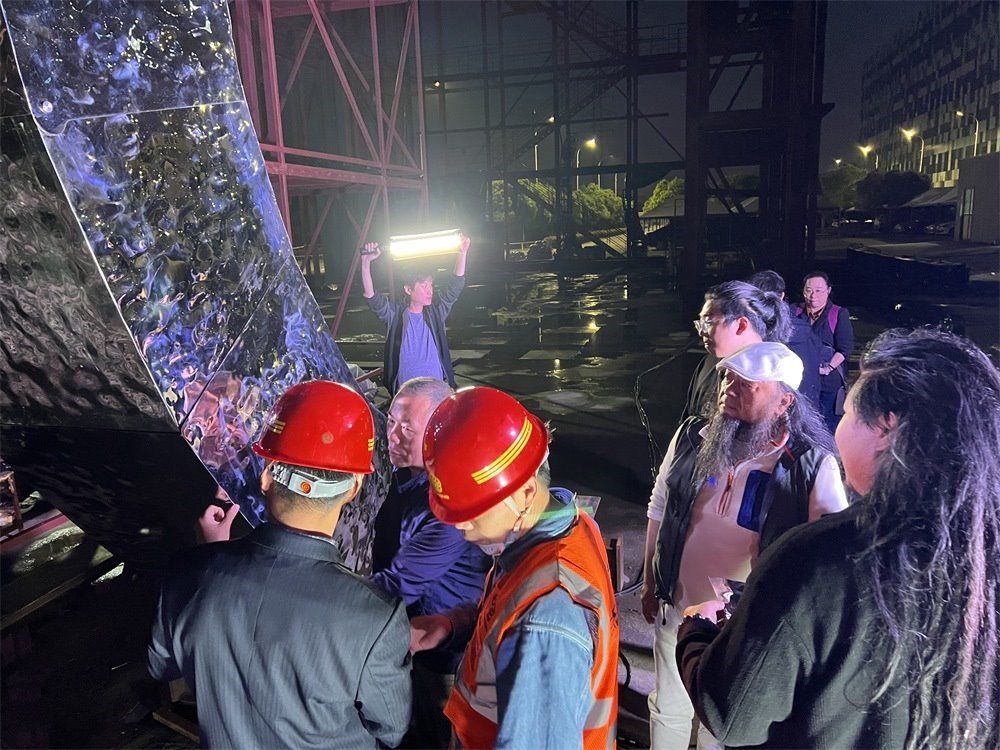 林崗（右二）和團隊查看主火炬制作進度。受訪者供圖