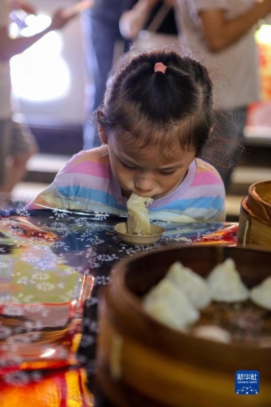 9月27日，小朋友在南翔小籠長(zhǎng)街宴上品嘗南翔小籠。