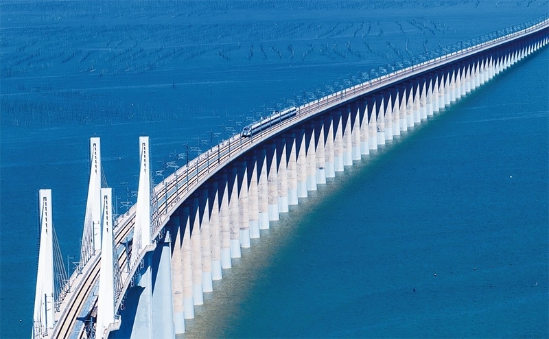 2023年9月28日，中國首條時速350公里跨海高鐵——福廈高鐵正式開通運(yùn)營。圖為一列運(yùn)行試驗(yàn)車組駛過福廈高鐵湄洲灣跨海大橋（9月19日攝，無人機(jī)照片）。 新華社記者 魏培全/攝