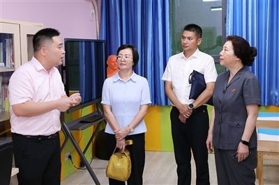 圖③：“小公民法律課堂”開講前，全國(guó)人大代表殷其龍（右二）、重慶市人大代表李自玲（左二）聽取楊家坪中學(xué)負(fù)責(zé)人關(guān)于未成年人思想教育工作情況的介紹。