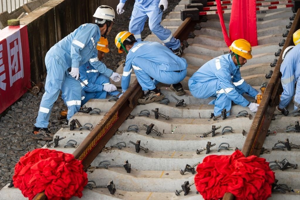 3月31日，在印度尼西亞雅加達雅萬高鐵哈利姆車站，工人鋪設雅萬高鐵全線最后一根鋼軌。