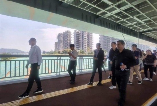 10月24日，2023“一帶一路”媒體合作論壇聯(lián)合采訪團(tuán)團(tuán)員走在清水塘大橋景觀通道上。本報(bào)記者 常雯宜攝