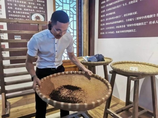 2023“一帶一路”媒體合作論壇聯(lián)合采訪(fǎng)團(tuán)團(tuán)員在非遺文化展示館體驗(yàn)中藥炮制技藝。（本報(bào)記者 黃超攝）