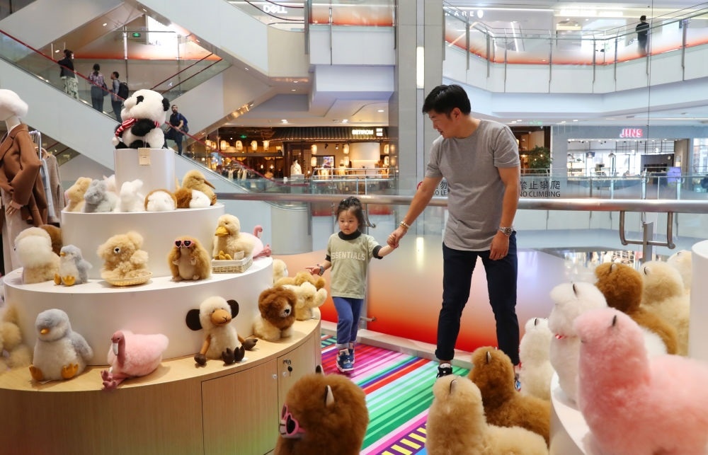 2023年11月2日，顧客在溫暖駝品牌專柜內(nèi)選購。連續(xù)六年參加進(jìn)博會(huì)的秘魯羊駝制品品牌溫暖駝在上海市中心商場(chǎng)開設(shè)了專柜。新華社記者 方喆 攝