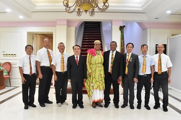 多米尼克總統(tǒng)伯頓和駐多米尼克大使林先江與中國(guó)農(nóng)業(yè)技術(shù)專家組合影。中國(guó)駐多米尼克大使館供圖