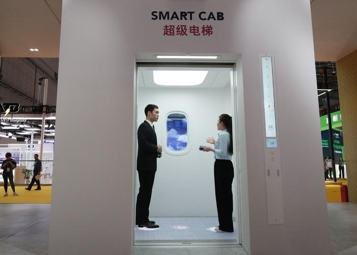 11月5日，工作人員（右）在第六屆進(jìn)博會(huì)上向參觀者介紹奧的斯公司全新推出的超級(jí)電梯。