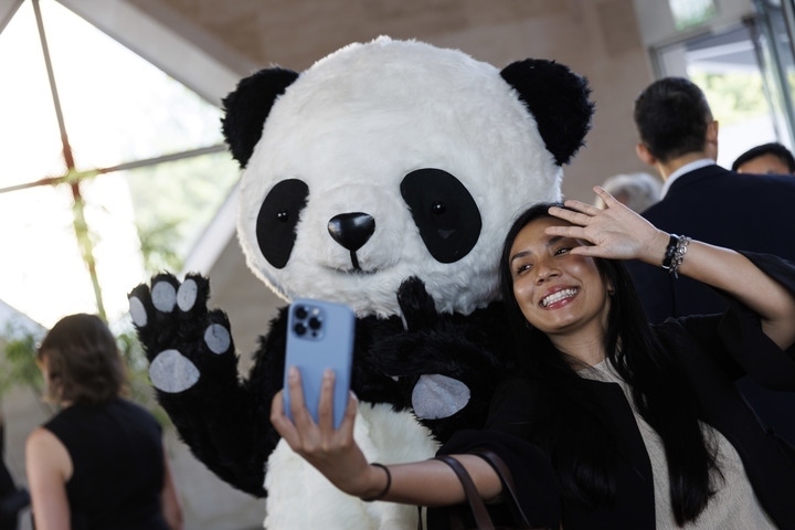 2022年8月24日，在美國(guó)華盛頓中國(guó)駐美國(guó)大使館，來(lái)賓與大熊貓玩偶合影。